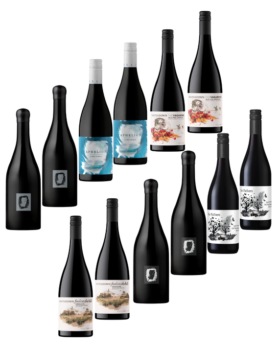 A group of wine bottles arranged on a plain white background, including several dark bottles with labels and a few lighter bottles with blue, white, and scenic illustrations on the labels.